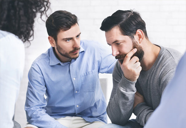 Support Group with a man comforting another man with a woman looking on